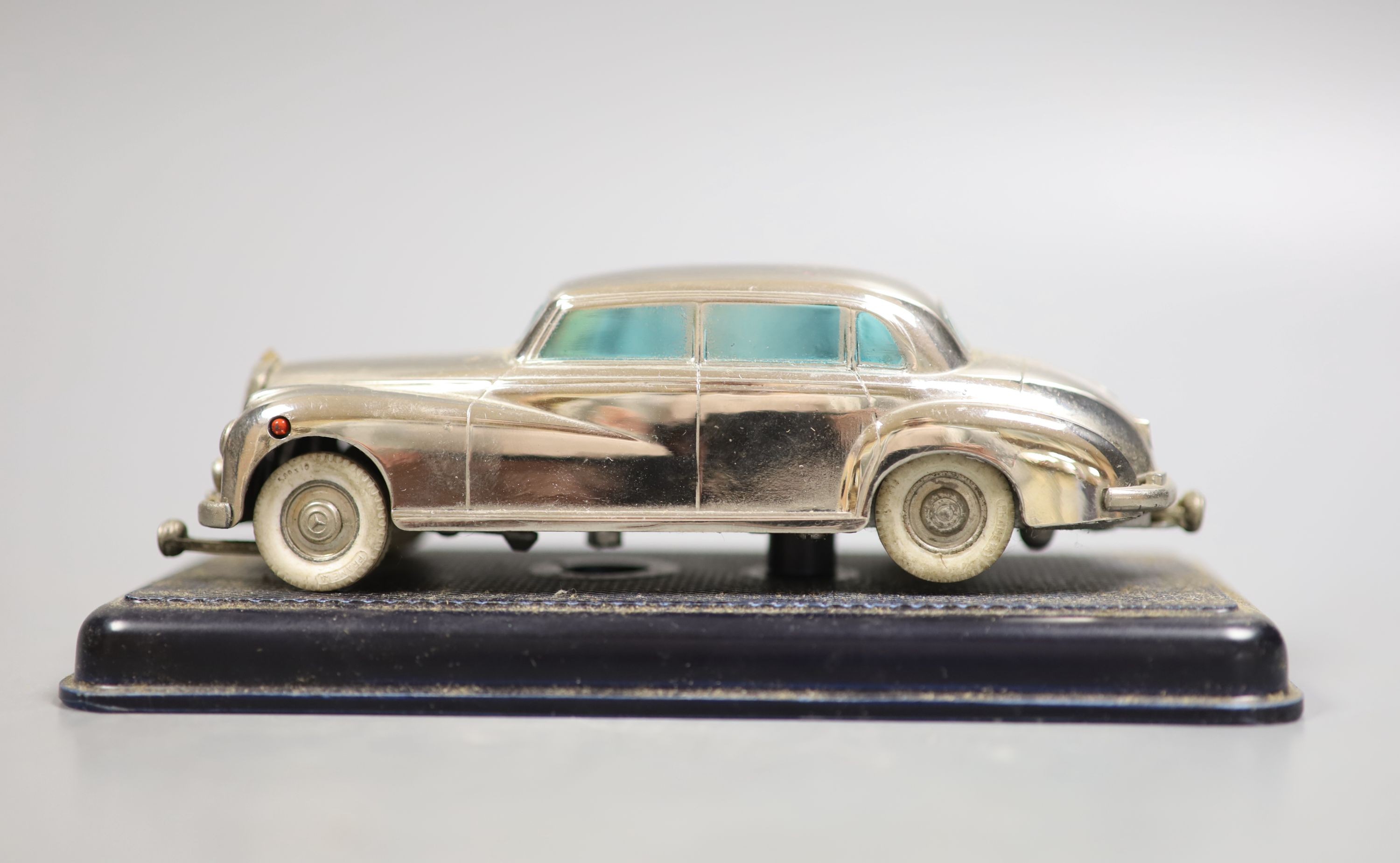 A Prameta clockwork Mercedes Benz 300, with base, 16cm long, instructions and remnants of box